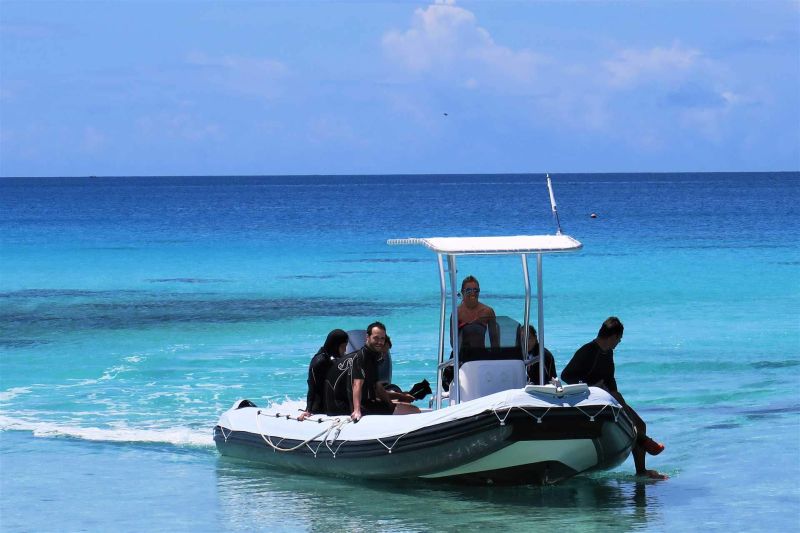 Divers aboard the Y AKA Plongée boat, setting off in the turquoise lagoon