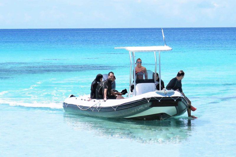 Small group of divers on board in the clear lagoon water